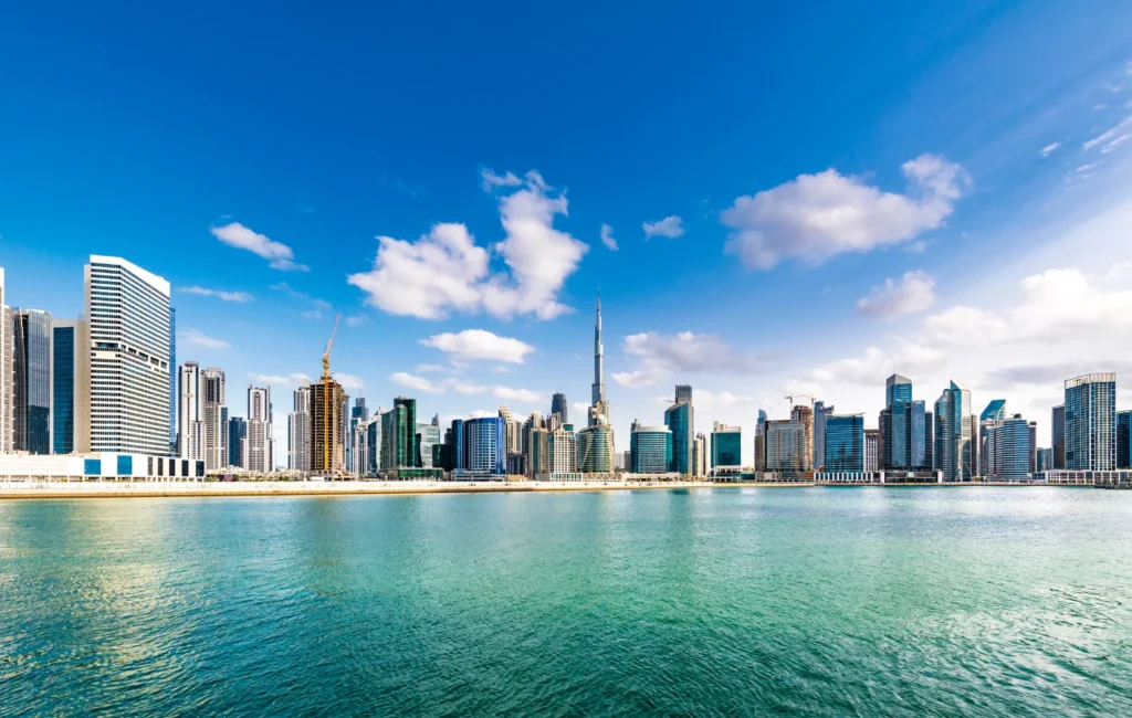 Stunning view of the Dubai skyline featuring iconic skyscrapers like the Burj Khalifa, illuminated against the evening sky.